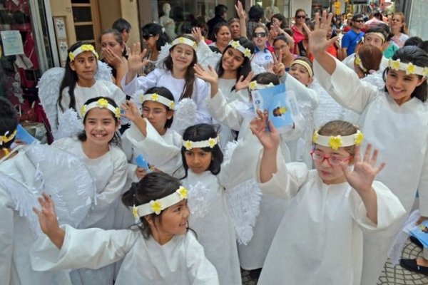 Niños vestidos de blanco visitan casas e instituciones