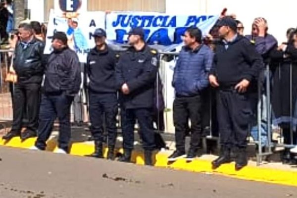 Imagen viral en un acto oficial: policías provinciales taparon un cartel que pedía por Loan