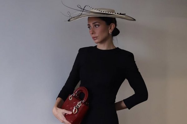 Un diez para la invitada de diciembre que combinó un elegante vestido midi con un bolso rojo